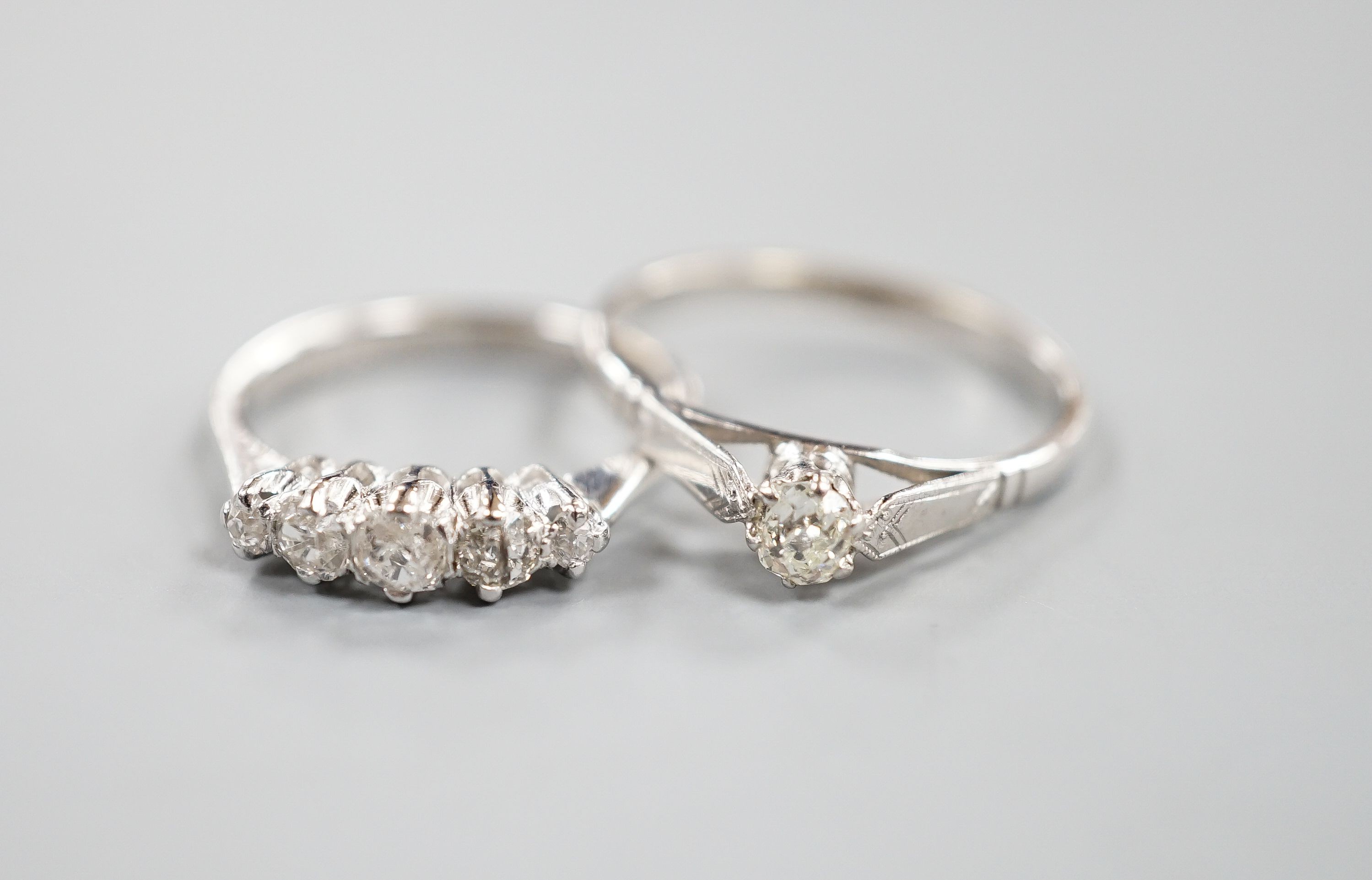 A modern 18ct gold and graduated five stone diamond set half hoop ring, size L and an 18ct and plat, solitaire diamond ring, size P/Q, gross weight 5.1 grams.